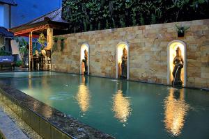 a swimming pool with lights in the water at Taman Ayu Legian Hotel in Legian