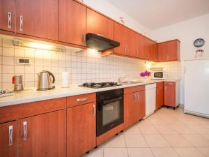 a kitchen with wooden cabinets and a white refrigerator at Apartment Adriana by Interhome in Pješčana Uvala  +15 photos