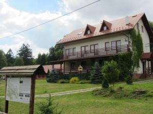 a large house with a sign in front of it at Ostoja w Lipowcu in Jaśliska