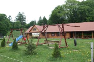 um parque com um parque infantil com um banco e baloiços em Ostoja w Lipowcu em Jaśliska