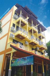 ein gelbes Gebäude mit Balkonen und einem Schild davor in der Unterkunft Amorn Mansion in Ao Nang Beach
