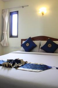 ein Bett mit blauen Kissen und einer Decke darauf in der Unterkunft Amorn Mansion in Ao Nang Beach