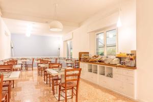 a restaurant with tables and chairs and a kitchen at Hotel Costa Verde in Castiglioncello
