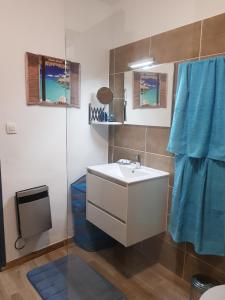 ein Badezimmer mit einem weißen Waschbecken und einem blauen Handtuch in der Unterkunft 60m2, 2 chambres proche Hérault & plages in Agde