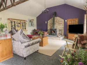 a living room with a couch and a fireplace at Willow Lodge in Brough