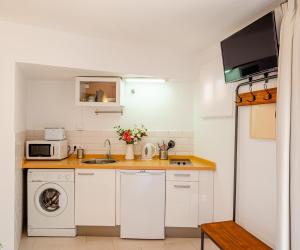 una cucina con lavandino e lavatrice di SEAFRONT WITH TERRACE a Málaga