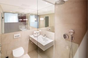 W łazience znajduje się umywalka i przeszklony prysznic. w obiekcie Cityhotel am Thielenplatz w Hanowerze