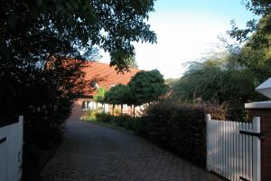 une maison avec une clôture blanche et une allée dans l'établissement Ferienwohnung am Wulfkamp, à Velen