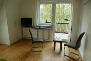 Cette chambre dispose d'un bureau, de deux chaises et d'une fenêtre. dans l'établissement Ferienwohnung am Wulfkamp, à Velen