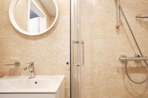 y baño con ducha, lavabo y espejo. en Cosy studio near Akropolis and Švyturio arena, en Klaipėda