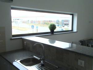 een keuken met een wastafel en een groot raam bij RM newhost 2015 / CasaDoChico in Portalegre