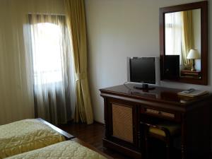 a bedroom with a bed and a television on a dresser at Casa Domneasca in Curtea de Argeş