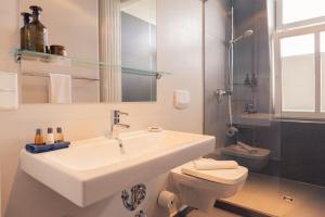 a white bathroom with a sink and a toilet at OSTKÜSTE - Villa Albatros Design Apartments in Ahlbeck