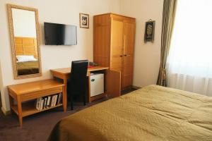 a bedroom with a bed and a desk and a mirror at Hotel Vila Diemedis in Palanga