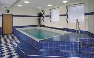 捷克賈布朗尼城的住宿－布里吉酒店，一间蓝色瓷砖浴室,内设浴缸