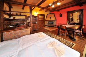 een slaapkamer met een bed, een tafel en een open haard bij Apartmány Village in Veľký Slavkov