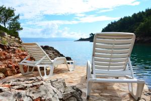 two chairs sitting on the shore of a body of water at Bay House Rosohotnica in Vrboska +39 photos