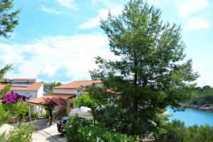 a car parked in front of a house with a tree at Bay House Rosohotnica in Vrboska