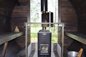 a wood stove in a cabin with two windows at Skogsbacka Torp in Tammisaari