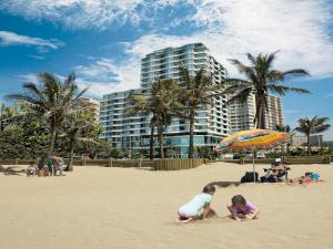 a group of children playing in the sand on the beach at Blue Waters Hotel in Durban