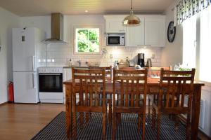 cocina con mesa, sillas y nevera en Countryside Villa Skogsbacka, en Tammisaari