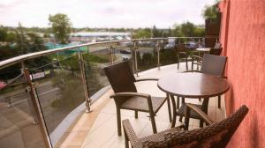 einen Balkon mit Tischen und Stühlen und Blick auf eine Straße in der Unterkunft Vinci Hotel Airport in Modlniczka