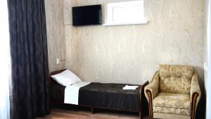 カメンノモスツキーにあるGuest house Dom Turistaの小さなベッドルーム(ベッド1台、椅子付)