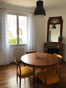 a dining room with a table and chairs and a mirror at Chez Mumu in Périgueux