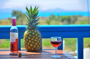 una botella y una copa de vino y una piña en Summer Memories Studios en Naxos