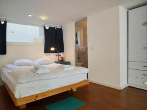 a bedroom with a large bed with a window at AirTLV - Centrally Located Studio With Gallery in Tel Aviv