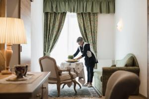 una mujer parada en una mesa en una habitación de hotel en Laguscei Dolomites Mountain Hotel en Arabba