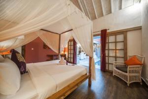 a bedroom with a large bed with a canopy at Coco Poco Villa Seminyak in Seminyak