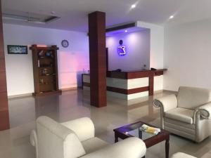 a living room with two chairs and a table at Kallada Sangeetha Hotels in Trichūr