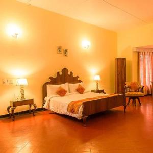 une chambre avec un grand lit et deux tables de nuit dans l'établissement Ama Plantation Trails, Chikmagalur, à Chikmagalur