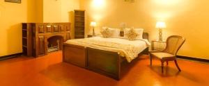 - une chambre avec un lit, une chaise et une cheminée dans l'établissement Ama Plantation Trails, Chikmagalur, à Chikmagalur