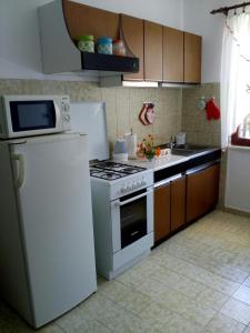 a kitchen with a white stove and a refrigerator at Apartman Knapić in Koromačno