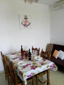 a dining room table with a floral table cloth on it at Apartman Knapić in Koromačno