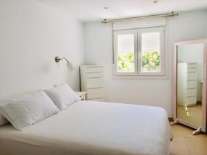 biała sypialnia z łóżkiem i oknem w obiekcie Casa Luz w mieście Tarifa