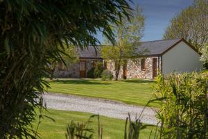 a stone house with a gravel road in front of it at Crib Goch Cottage in Llanfairpwllgwyngyll