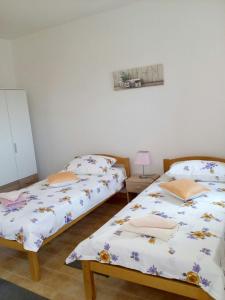 two beds sitting next to each other in a room at Apartman Knapić in Koromačno