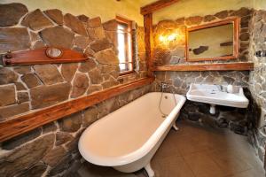 a stone bathroom with a bath tub and a sink at Apartmány Village in Veľký Slavkov +25 photos
