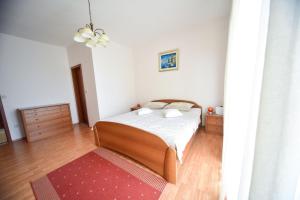 Schlafzimmer mit einem Bett und einem roten Teppich in der Unterkunft Apartment Marcella 1 in Ljubač