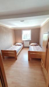 a room with two beds and a window at Pokoje do wynajęcia Piastowska in Międzyrzecz