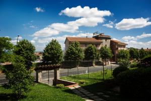 a large building with a fence and trees at Albergo Di Murlo in Murlo
