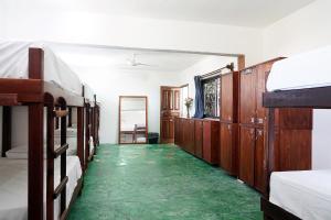Pokój z łóżkiem piętrowym i zieloną podłogą w obiekcie Red Panda Hostal w mieście Playa del Carmen