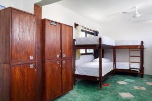 a room with two bunk beds and wooden cabinets at Red Panda Hostal in Playa del Carmen