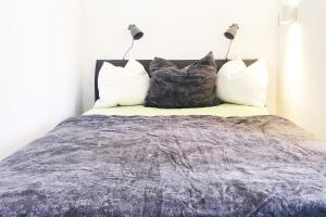 - une chambre avec un lit et trois oreillers dans l'établissement Gemütliches Apartment mit Balkon und Tiefgaragenstellplatz, à Wuppertal