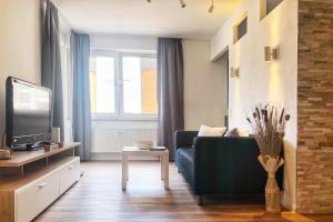 a living room with a couch and a tv at Gemütliches Apartment mit Balkon und Tiefgaragenstellplatz in Wuppertal