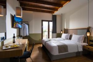 a hotel room with a large bed and a desk at Petousis Hotel & Suites in Amoudara Herakliou