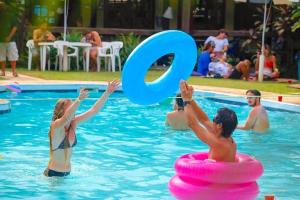 um grupo de pessoas brincando em uma piscina em VELINN Pousada dos Marinheiros em Ilhabela
